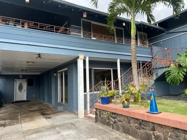 A blue building with a white door and a balcony.